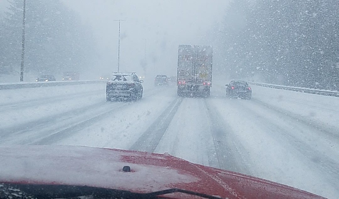 Snow-covered highway with cars and trucks driving