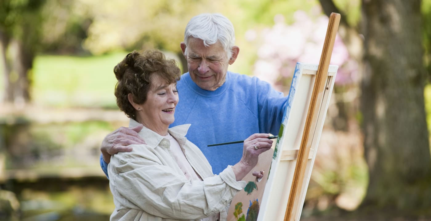 Older couple painting together outside