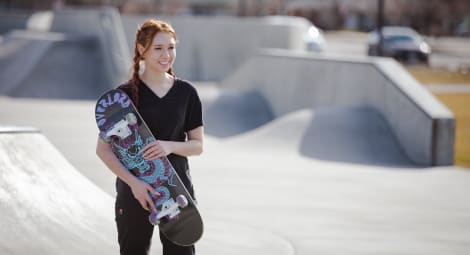 Teen girl holding a skateboard