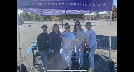 Five Mary Bridge Children’s employees standing next to one another outside under a tent