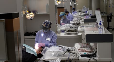 Looking down a hallway at dental students working on patients