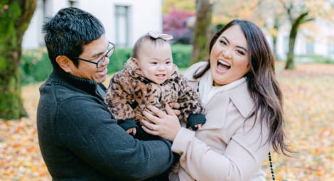 Little girl being held by parents