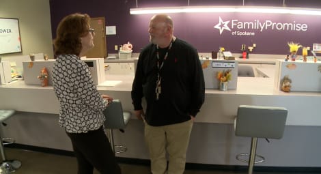 Man and woman talking in front of a desk