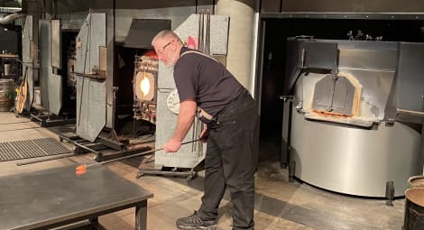 Veteran John Obermuller rolls hot glass on the work surface at the Museum of Glass