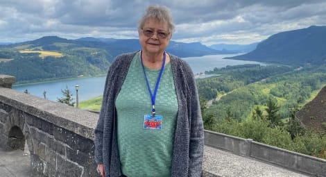 woman standing in front of scenic river viewpoint