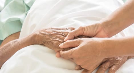 Holding hands in a hospital bed