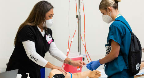 Nurse shows student how to draw blood using a training prosthetic