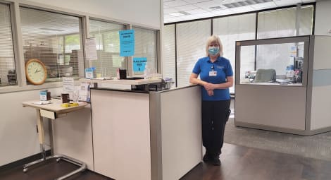 Hospital worker standing in front of a desk.