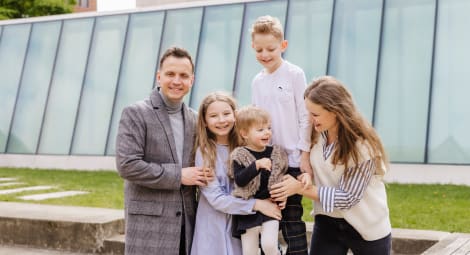 Family sitting on bench poses for camera