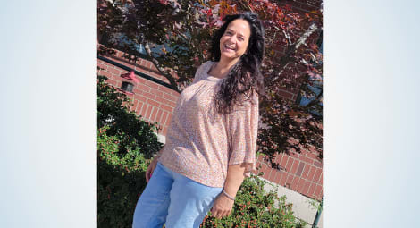 Woman posing in a pink shirt and jeans following weight loss surgery.