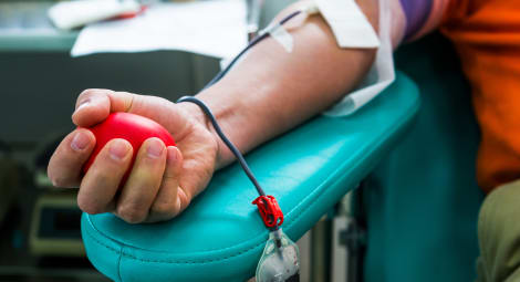 Hand grabbing a stress ball to give blood.