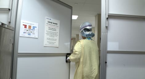 Medical professional in gown enters room