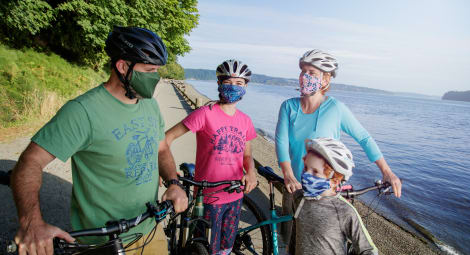 Family biking with masks on