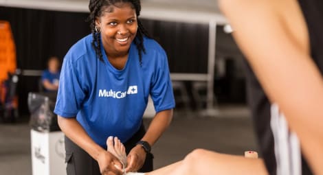 Volunteer medical professional helping with a hurt ankle.