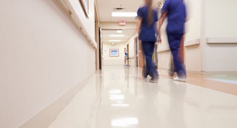 Two nurses walking down hospital hallway