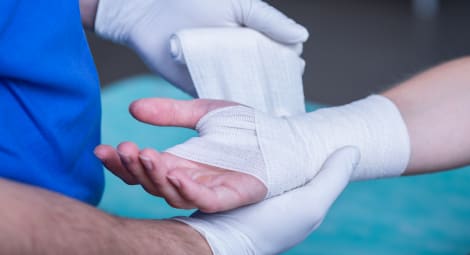 Wrist being wrapped in gauze by a health care provider