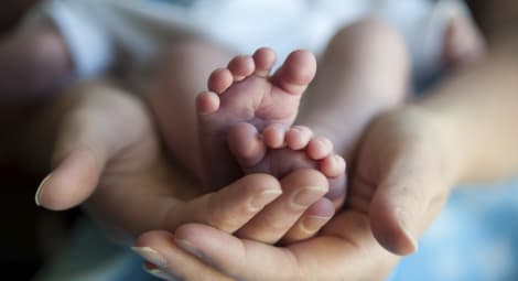 Woman holding baby showing feet