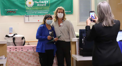 Melanie Ives, RN, and nurse manager Sarah Post, RN, pose for photos during the Daisy Award presentation ceremony