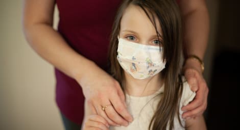 Girl wearing a mask looking at the camera