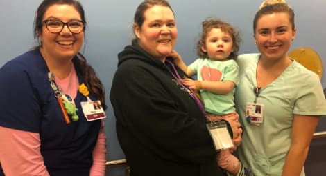 Three people standing with a child