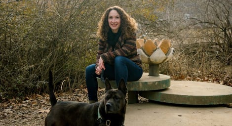 Woman sitting behind her dog