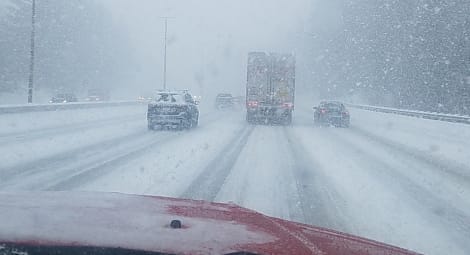 Snow-covered highway with cars and trucks driving