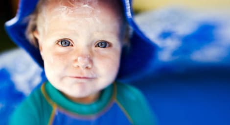 Toddler wearing sunscreen and a hat