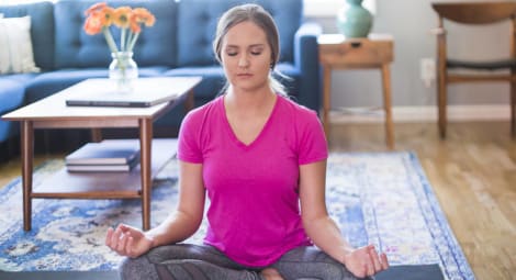 Woman doing yoga in living room