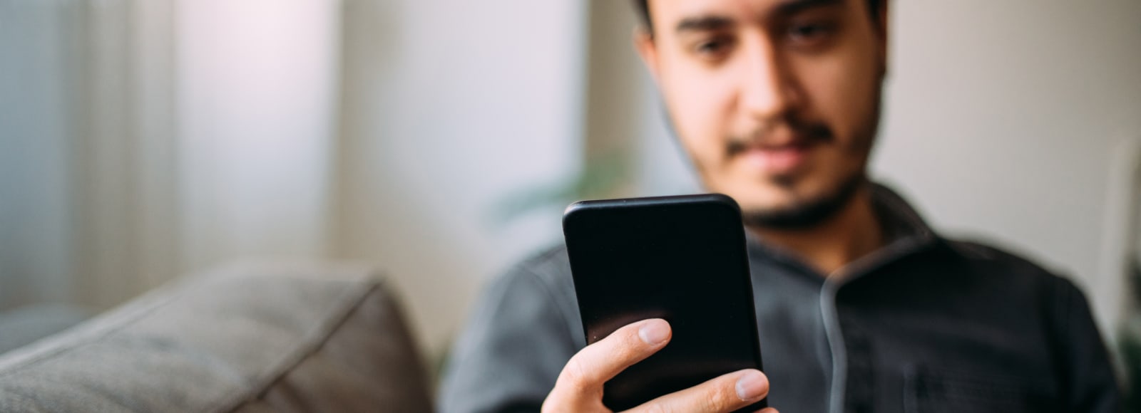 Man sitting on couch holding cell phone