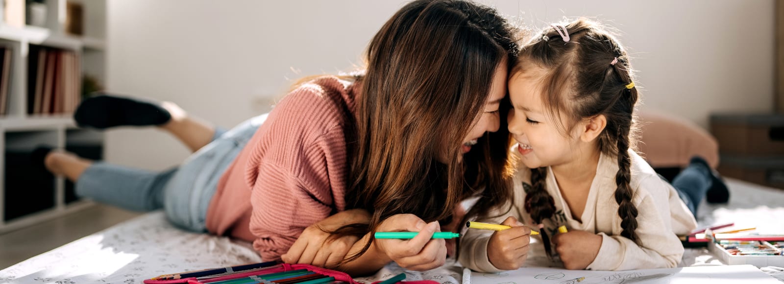 Mother and daughter bonding while drawing in their cozy bedroom