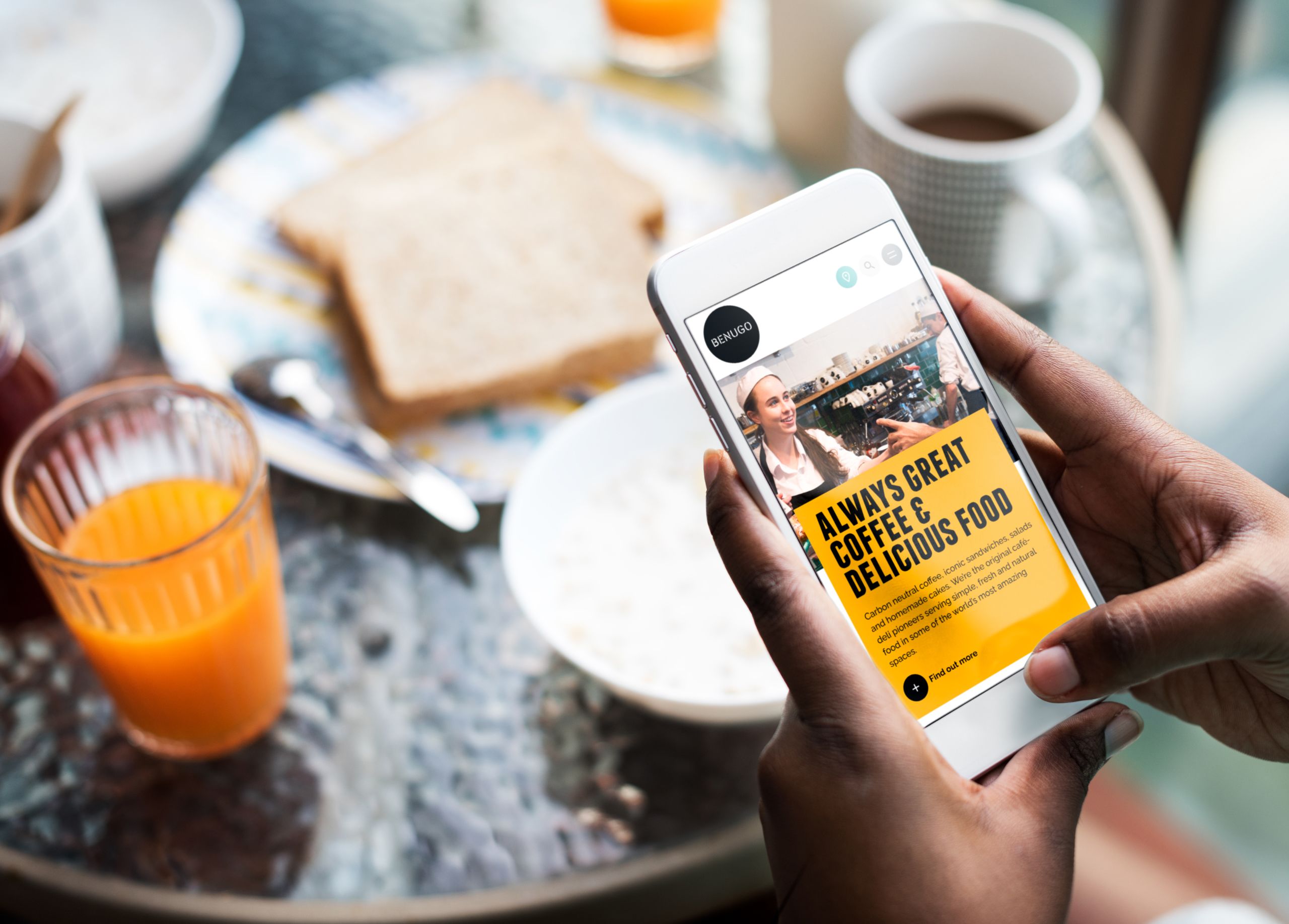 Woman holding phone at cafe looking at Benugo site