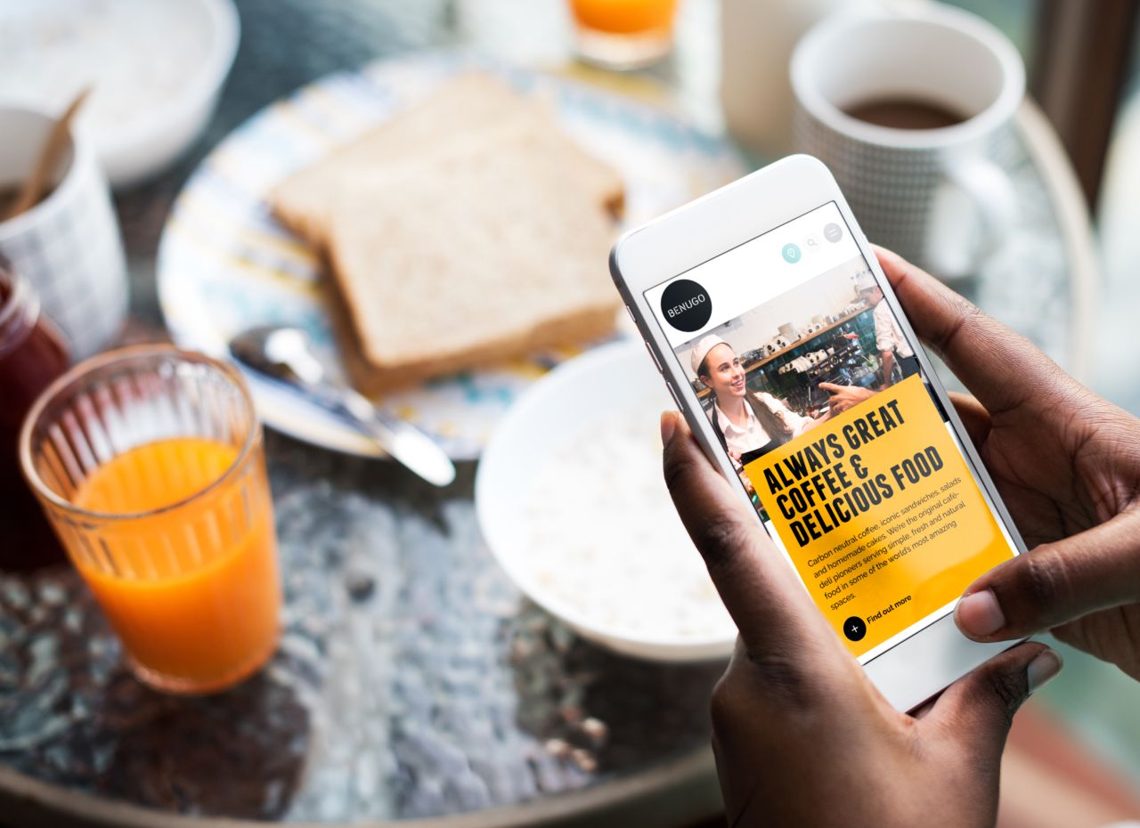 Woman holding iphone on Benugo website