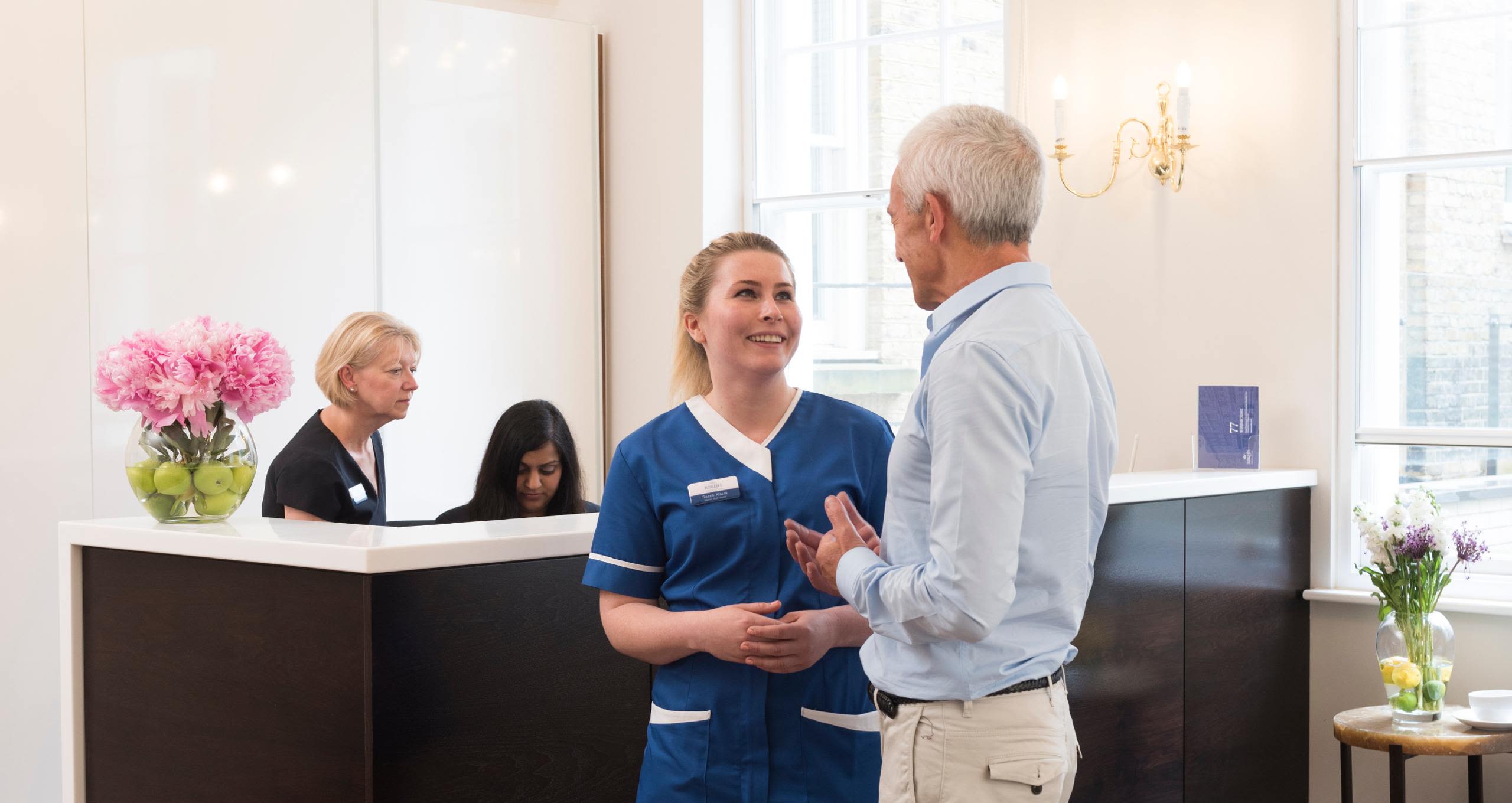 Patient talks to nurse in reception area