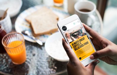 Woman holding phone in cafe on Benugo site