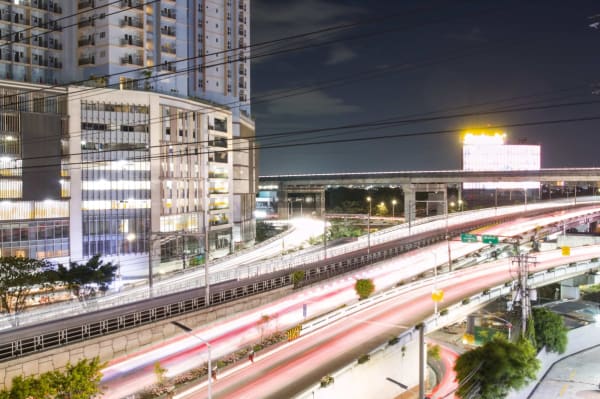 Long-exposure light trails from vehicles on an elevated Makati expressway at night