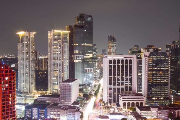 Makati's illuminated high-rise skyline and light trails viewed from an elevated vantage point at night