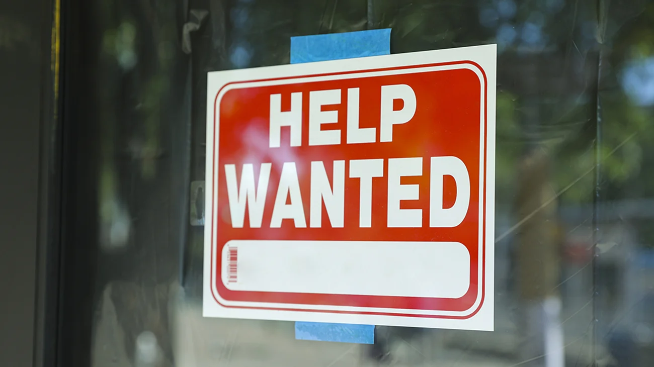 Help wanted sign in front of store front