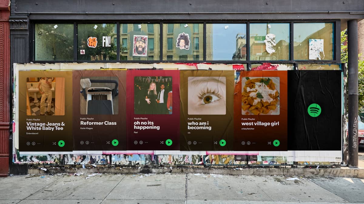 Cinco carteles pegados en una calle de Nueva York con portadas de playlists reales de Spotify y el logo de la marca.