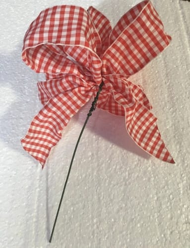 a ribbon attached to the stem of a silk flower