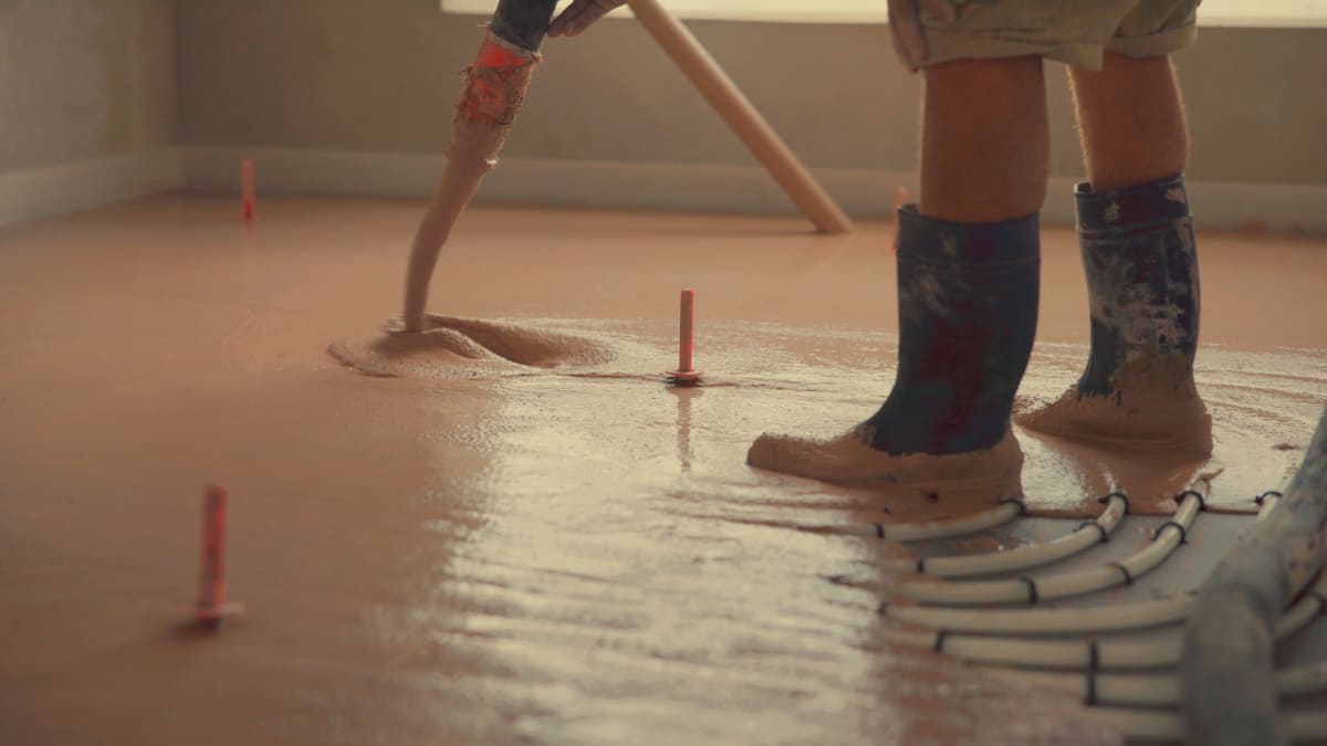 Estrichleger-Team beim Einbau von Fließestrich über Fußbodenheizung