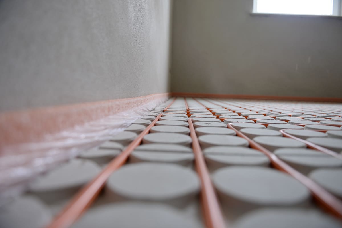 Dünnschichtsystem Fußbodenheizung: Ecke mit Randdämmstreifen und dünnen Heizrohren