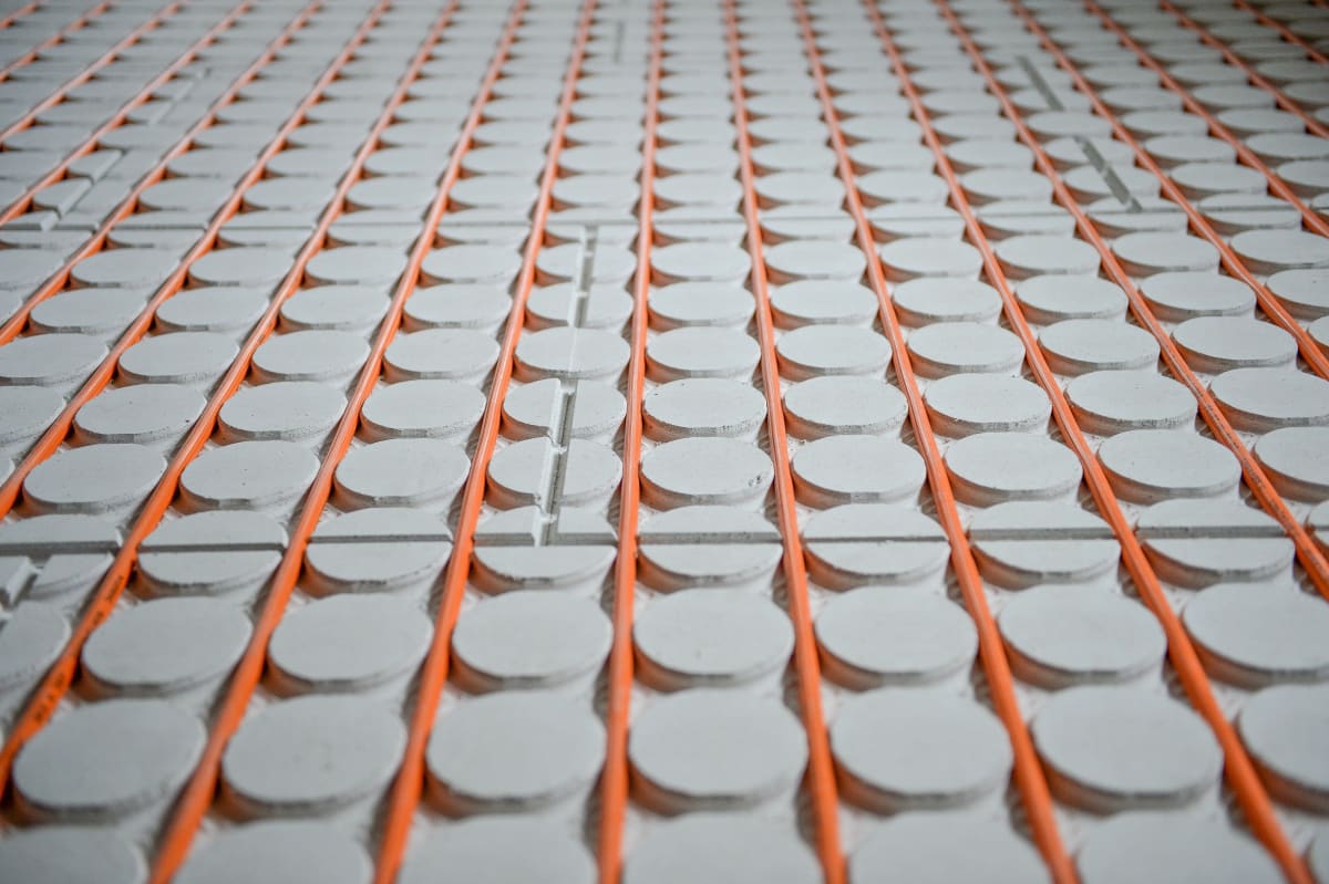 Dünnschichtsystem Nahaufnahme: Perforierte Systemplatten mit orangefarbenen Heizrohren