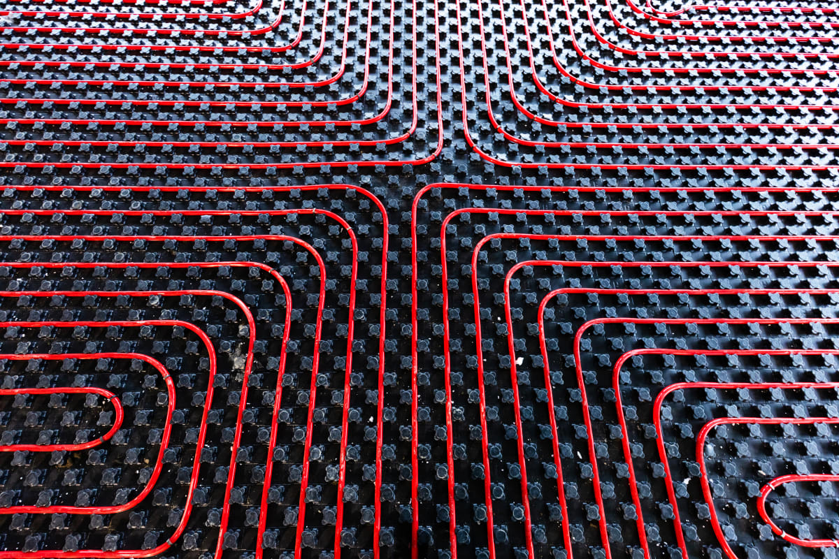 Noppensystem Detail: Rote PE-Xa Heizrohre in schwarzer Noppenplatte