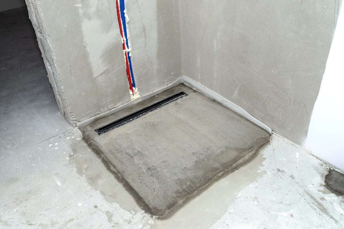 Gefälleestrich im Rohbau mit Duschrinne - präzises Gefälle zur Linearentwässerung sichtbar