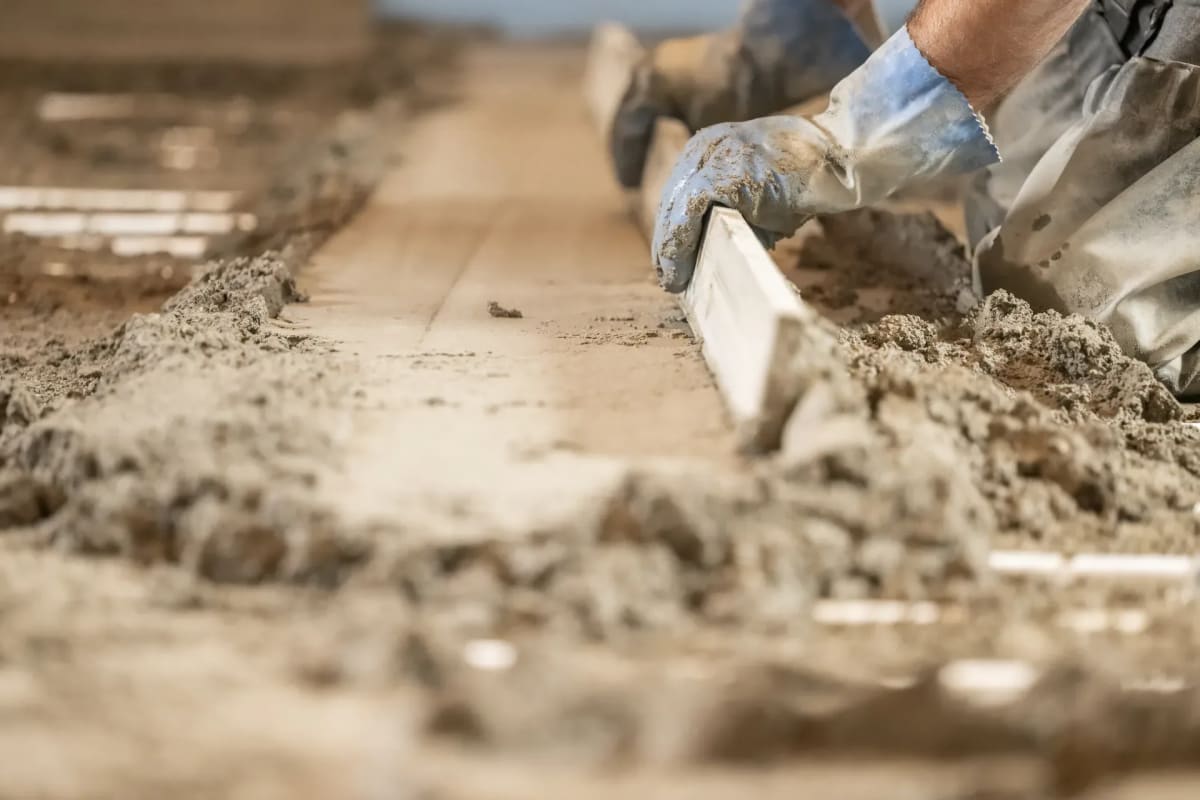 Zementestrich mit Abziehlatte abziehen