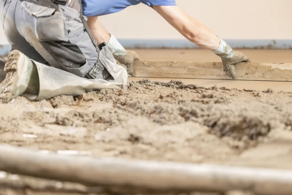 Zementestrich von Hand glätten im Rohbau