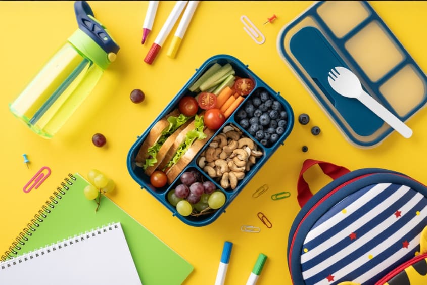 Foto van gezonde brooddoos en schoolmateriaal