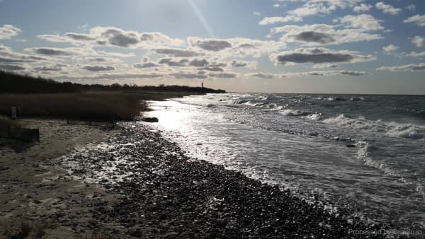 Rocky coastal shoreline with lighthouse in background