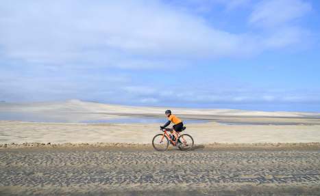Neil riding next to a flooded salt flat in Paracas National Park