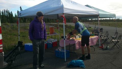 NAE 2013 - Stage 06 - HAiley (medic) watches Ilkka recharge his batteries at lunch  for another good 50 km of riding - by Nina